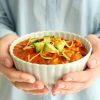 Woman holding bowl of delicious chili